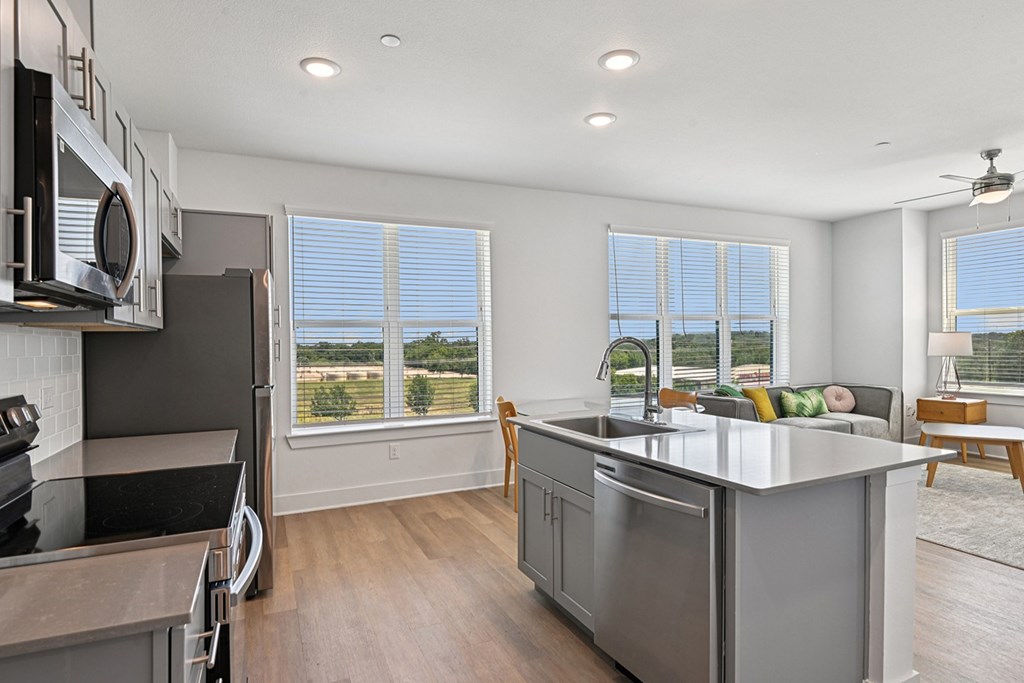 A modern kitchen with stainless steel appliances and a large island.