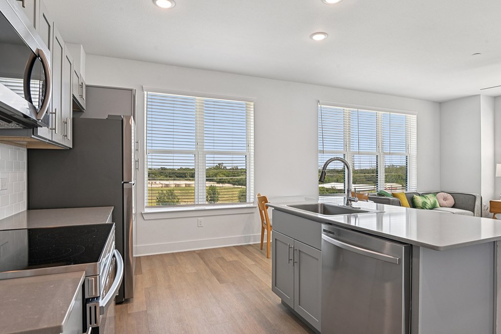 A modern kitchen with a stainless steel refrigerator and a dishwasher.