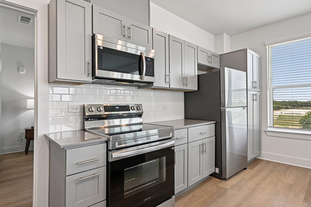 A modern kitchen with stainless steel appliances and white cabinets.