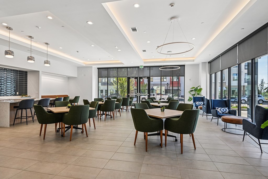 A modern dining area with green chairs and tables.