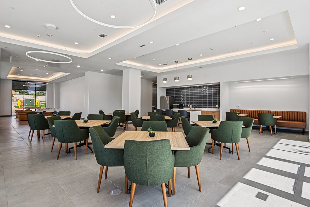 A modern dining room with green chairs and wooden tables.