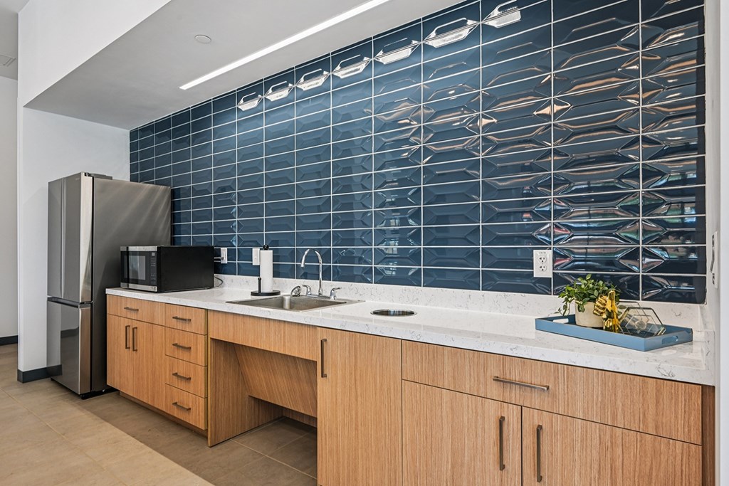 A kitchen with a wooden counter and a blue tile backsplash.