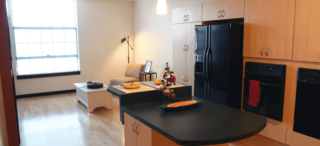 a kitchen with a black refrigerator and a black counter top