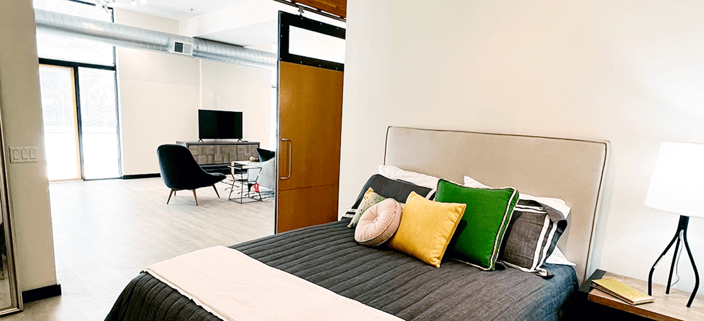 a bedroom with a bed and a desk with a lamp