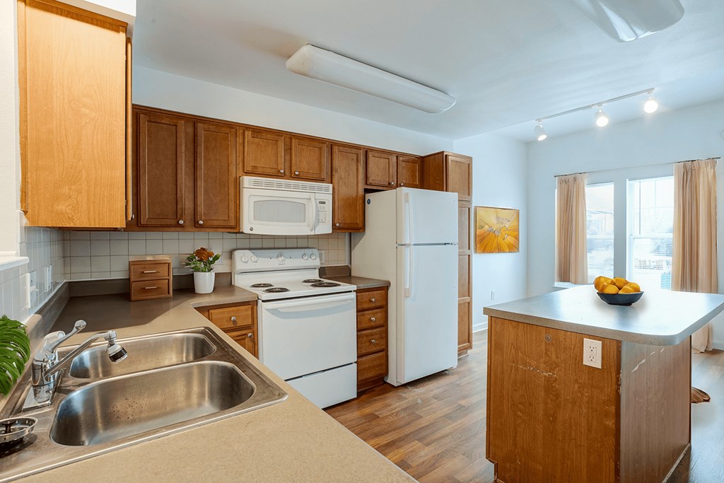 A kitchen with wooden cabinets and white appliances.