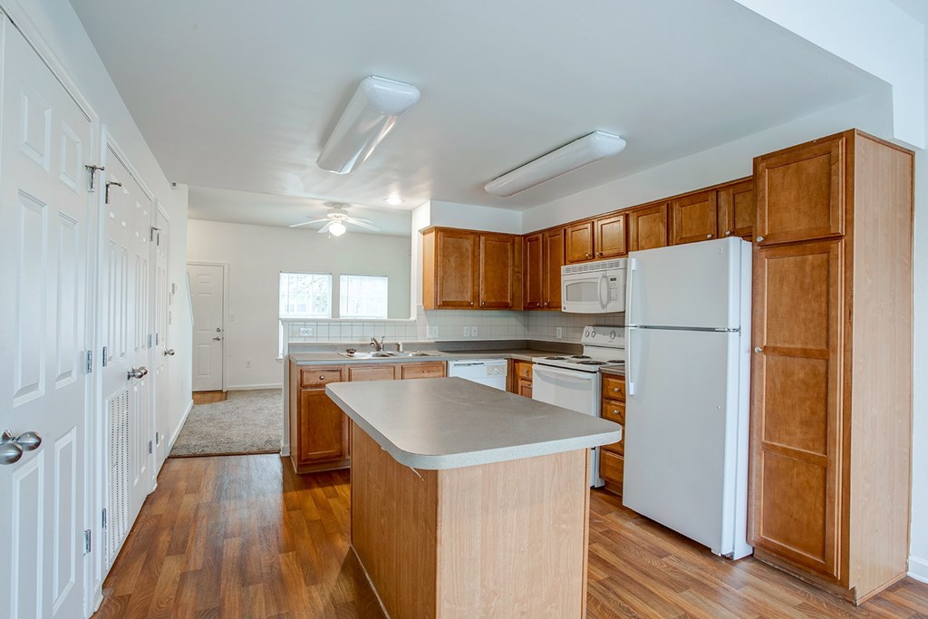 A kitchen with wooden cabinets and a white refrigerator.