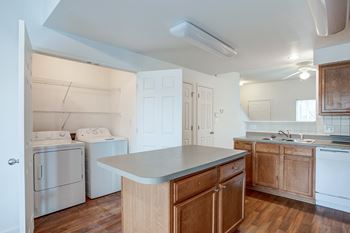 A kitchen with white appliances and wooden cabinets.