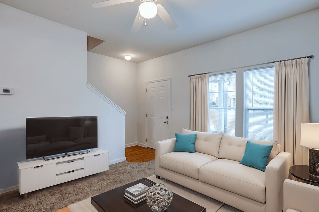 A living room with a white couch and a television.