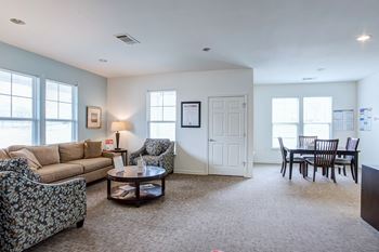 A living room with a sofa, armchair, and coffee table.