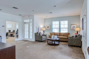 A living room with a brown carpet and furniture.