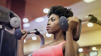 African American woman using exercise machine, Cedars at Carver Park Galveston, TX