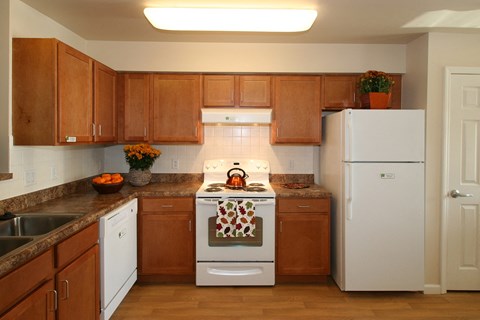 a kitchen with white appliances and wooden cabinets