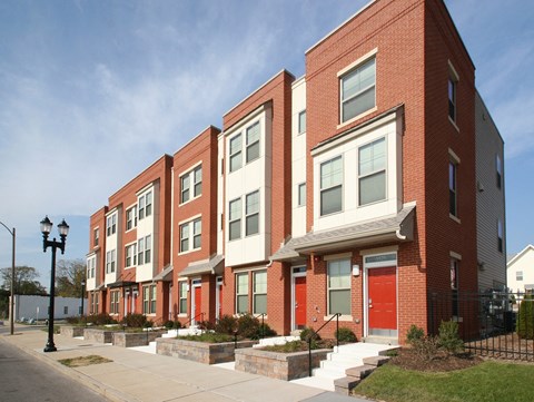 a row of brick apartment buildings with red doors