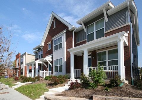 a row of town houses with a sidewalk in front of them