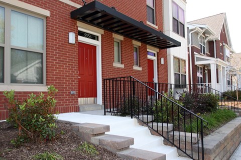 a red brick house with a red door and stairs