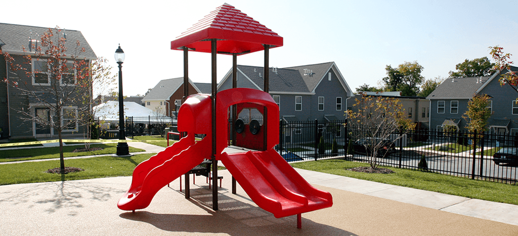 a playground with a red slide in a park
