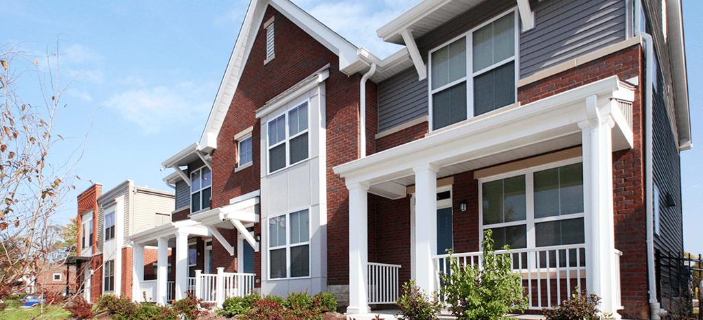 a row of town homes with brick and white columns