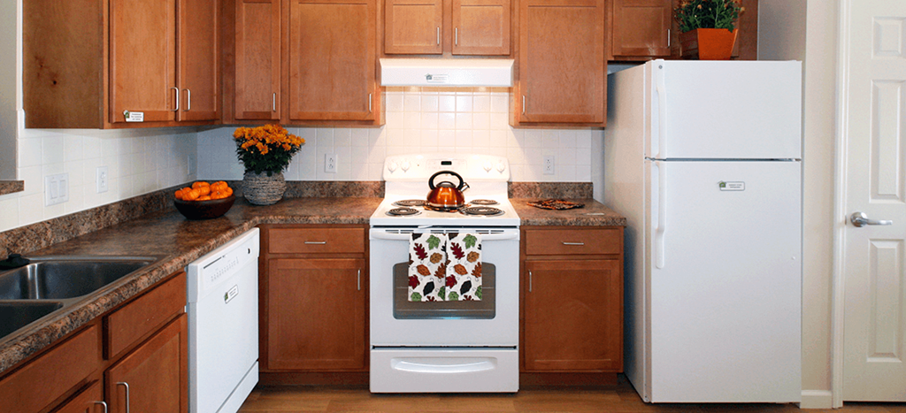 a kitchen with white appliances and wooden cabinets