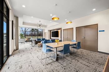 A conference room with a long table surrounded by chairs.