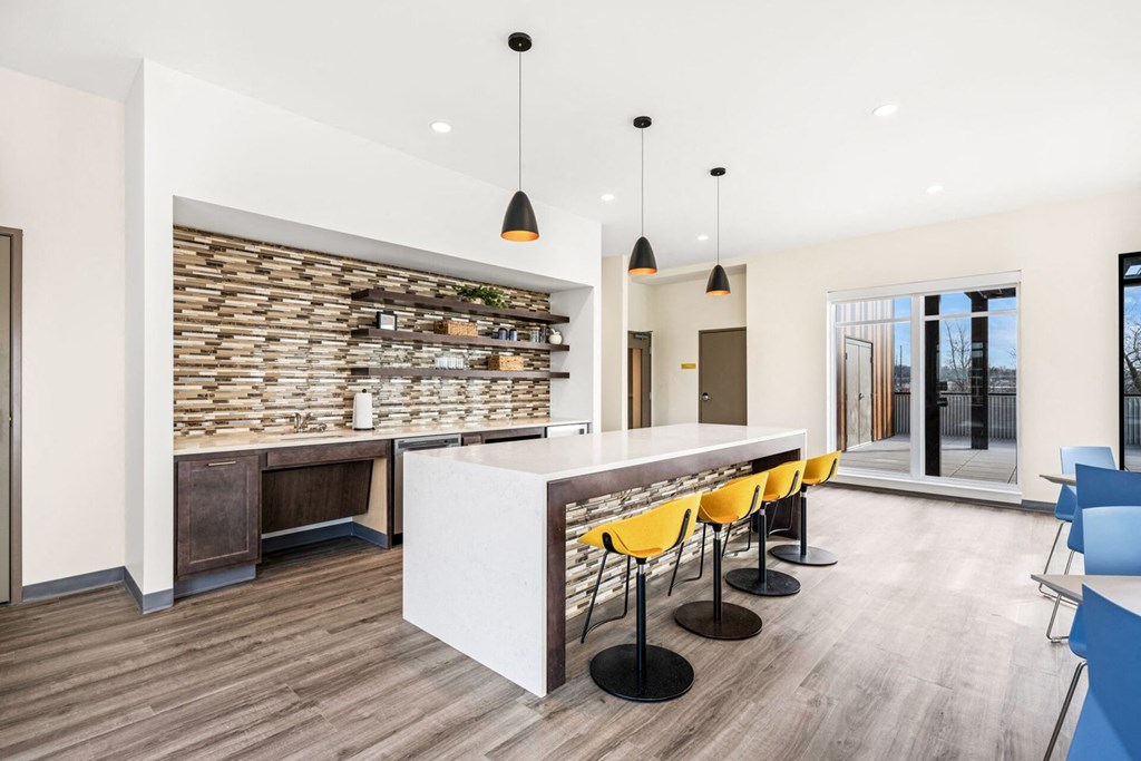 A modern kitchen with a white counter and yellow chairs.