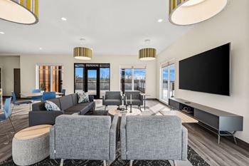 A modern living room with grey sofas and a large television.