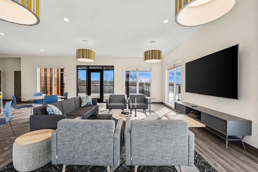 A modern living room with grey sofas and a large television.
