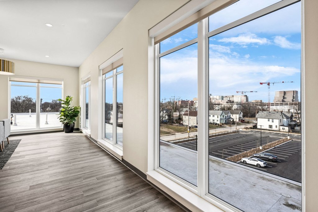 A large room with a view of a parking lot and buildings outside.
