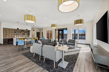 A modern living room with a grey couch and a wooden floor.