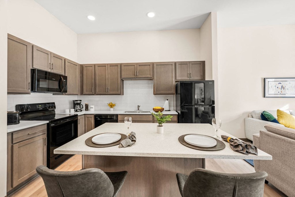 A modern kitchen with a dining table set for two.