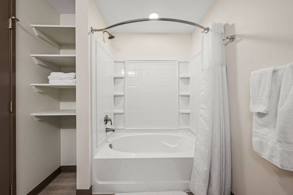 A white bathroom with a tub and a shower.
