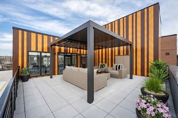 A modern building with a striped facade and a patio area with a table and chairs.