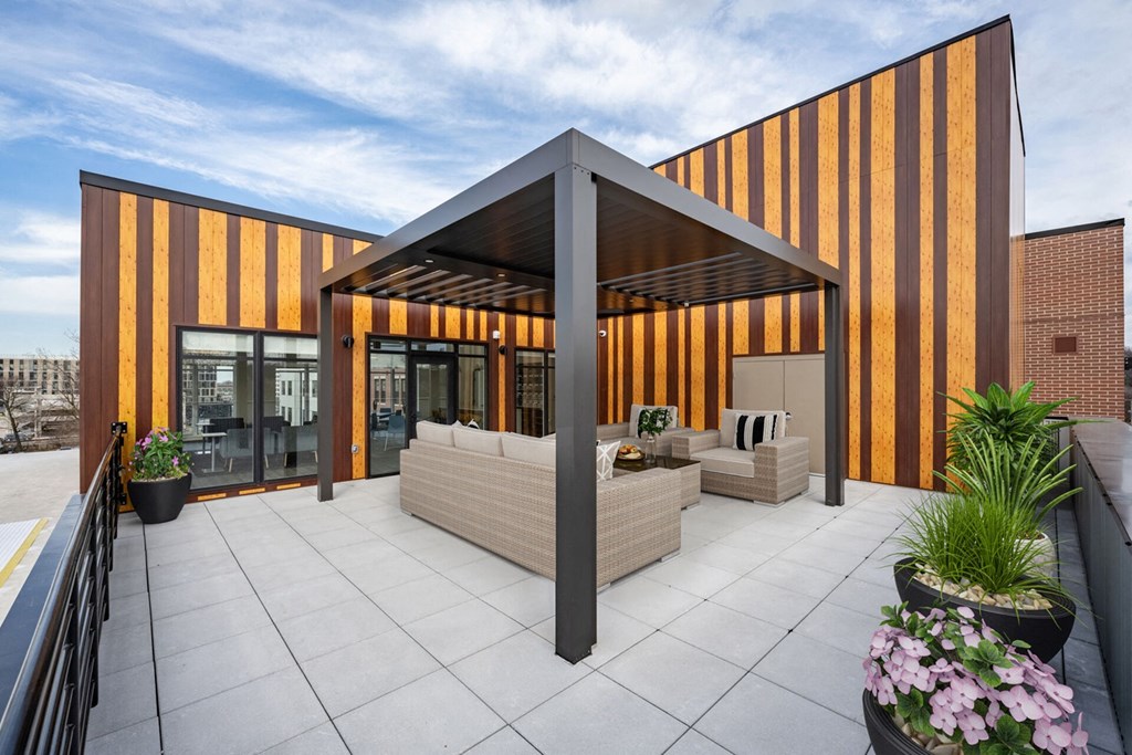 A modern building with a striped facade and a patio area with a table and chairs.