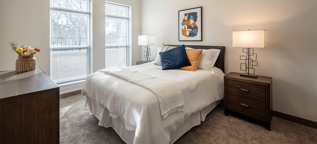 Aura at Innovation apartments model bedroom with a bed and two windows