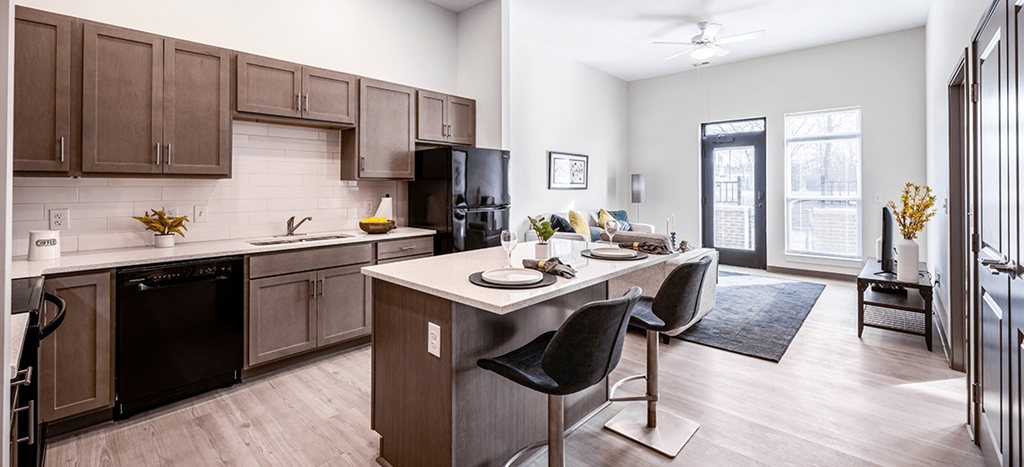 an open kitchen and living room with a table and chairs at Aura at Innovation Square apartments