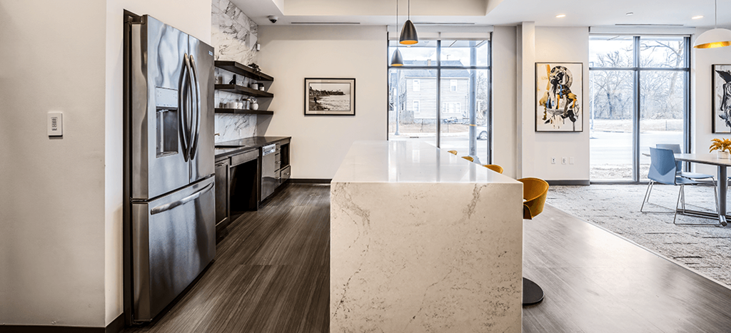 Clubhouse kitchen with a large island and a stainless steel refrigerator