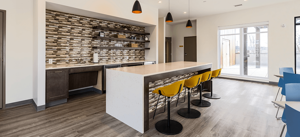 Clubhouse kitchen with a long counter and yellow chairs