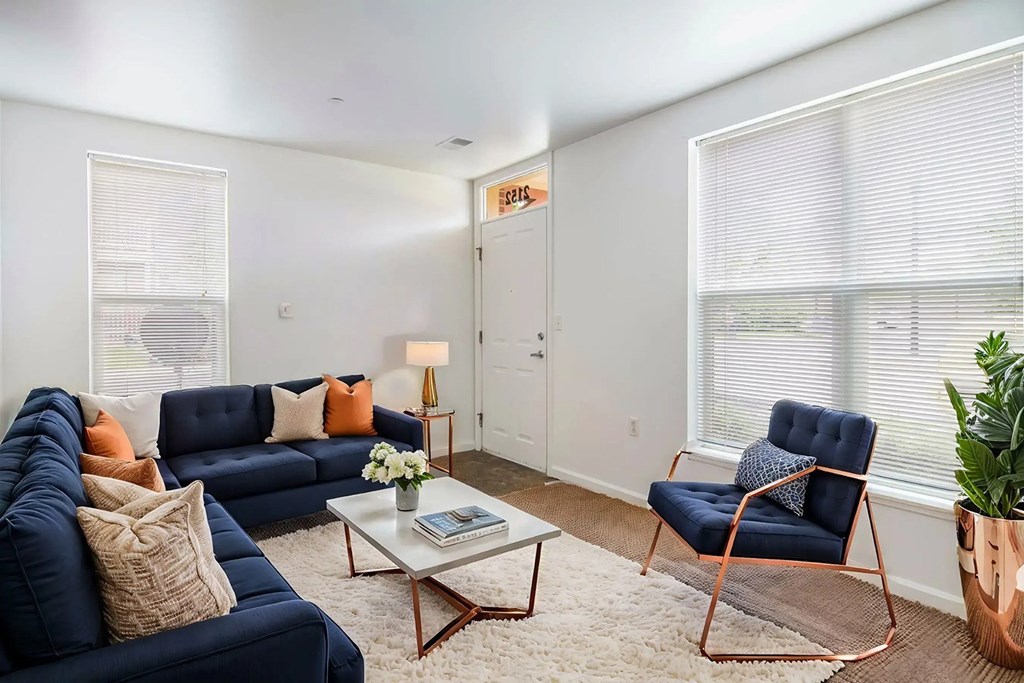 A living room with a blue sofa, a chair, and a coffee table.