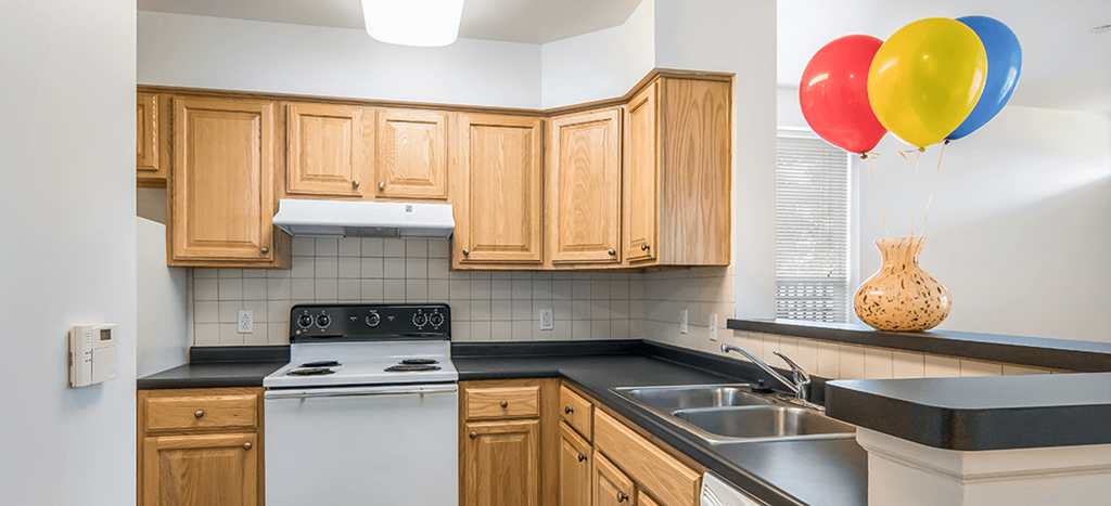 a kitchen with wooden cabinets and a stove and balloons