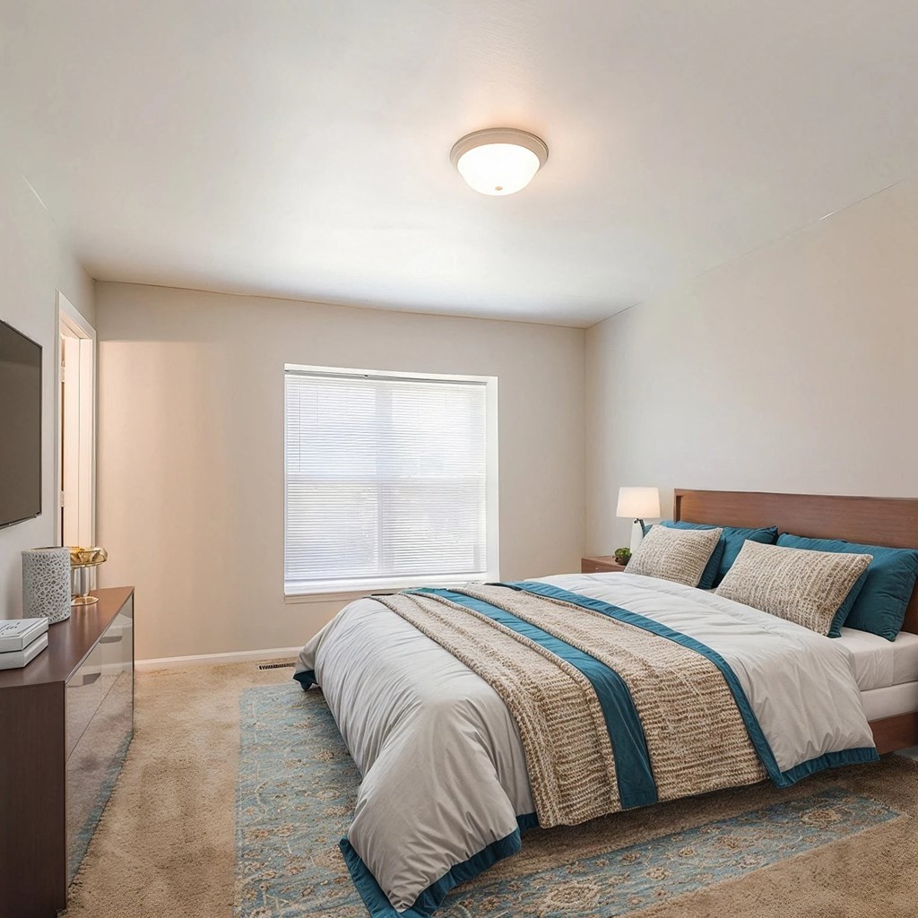 A bedroom with a large bed and a window.