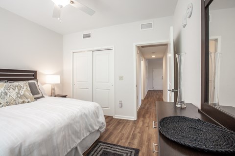 Apartment bedroom furnished with bed, vanity dresser, rug, and nightstand with lamp-Beecher Terrace, Louisville, KY