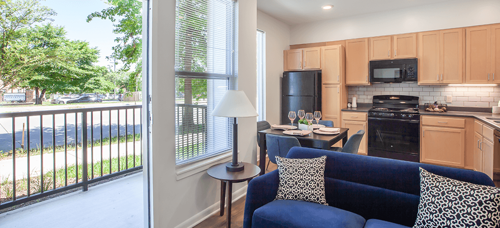 a living room with a kitchen and a balcony