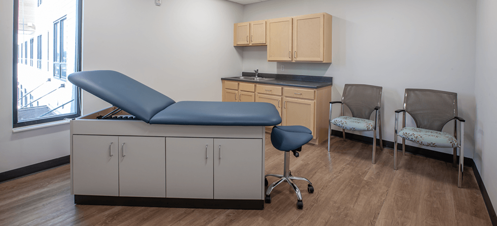 a exam room at Beecher Senior Apartments with a blue exam chair