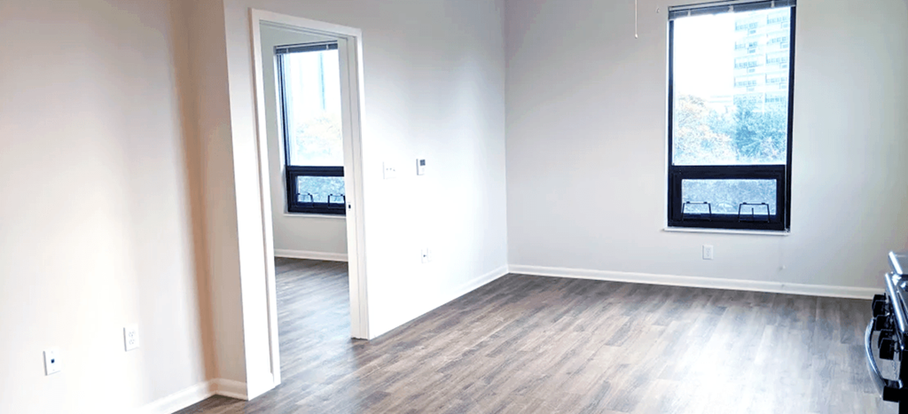 an empty living room with white walls and wood floors
