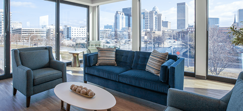 a living room with a blue couch and a view of the city
