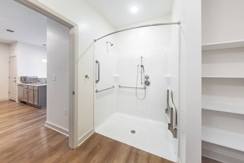 a white bathroom with a shower and a sink