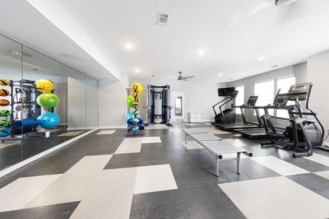 a fitness room with treadmills and other exercise equipment