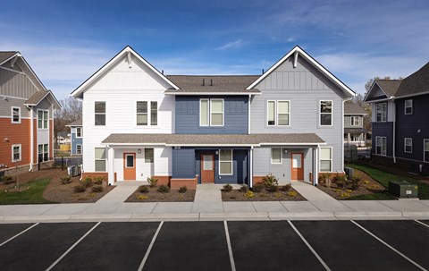 an exterior view of an apartment building with a parking lot