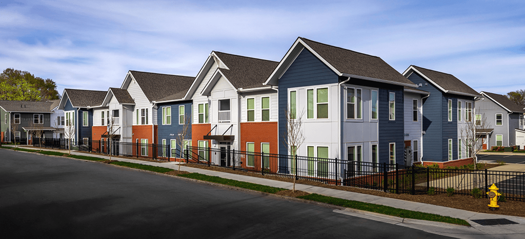 a row of colorful apartment homes in front of a street at Brown School Lofts