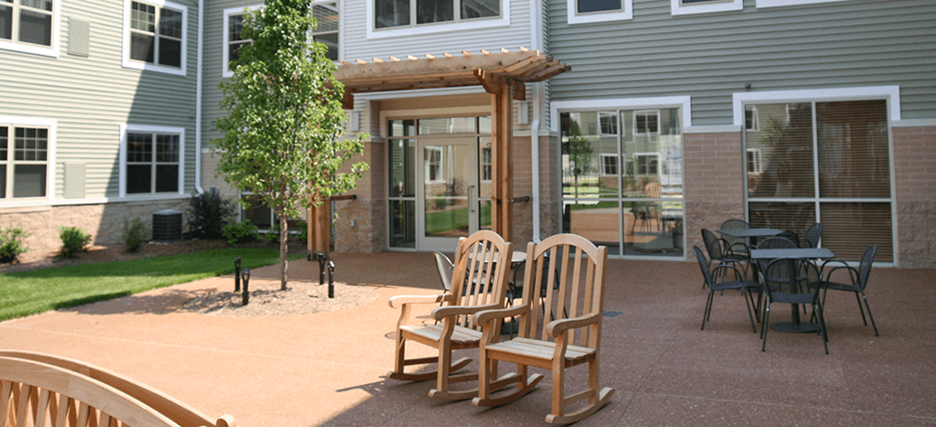 a courtyard with wooden chairs and a pergola at Cahill Apartments