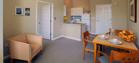 a living room and kitchen with a dining room table and chairs